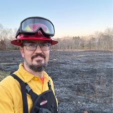 image of James Faupel wearing a red hard hat, safety googles, and yellow shirt