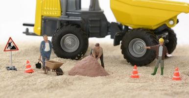 construction worker models in sand with toy truck