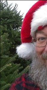 image of mike anderson in a santa hat and a pine tree in the background