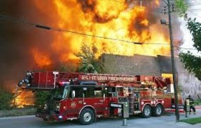 building on fire with a fire truck in the foreground