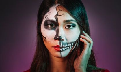 A photo of someone with black and white skull makeup.