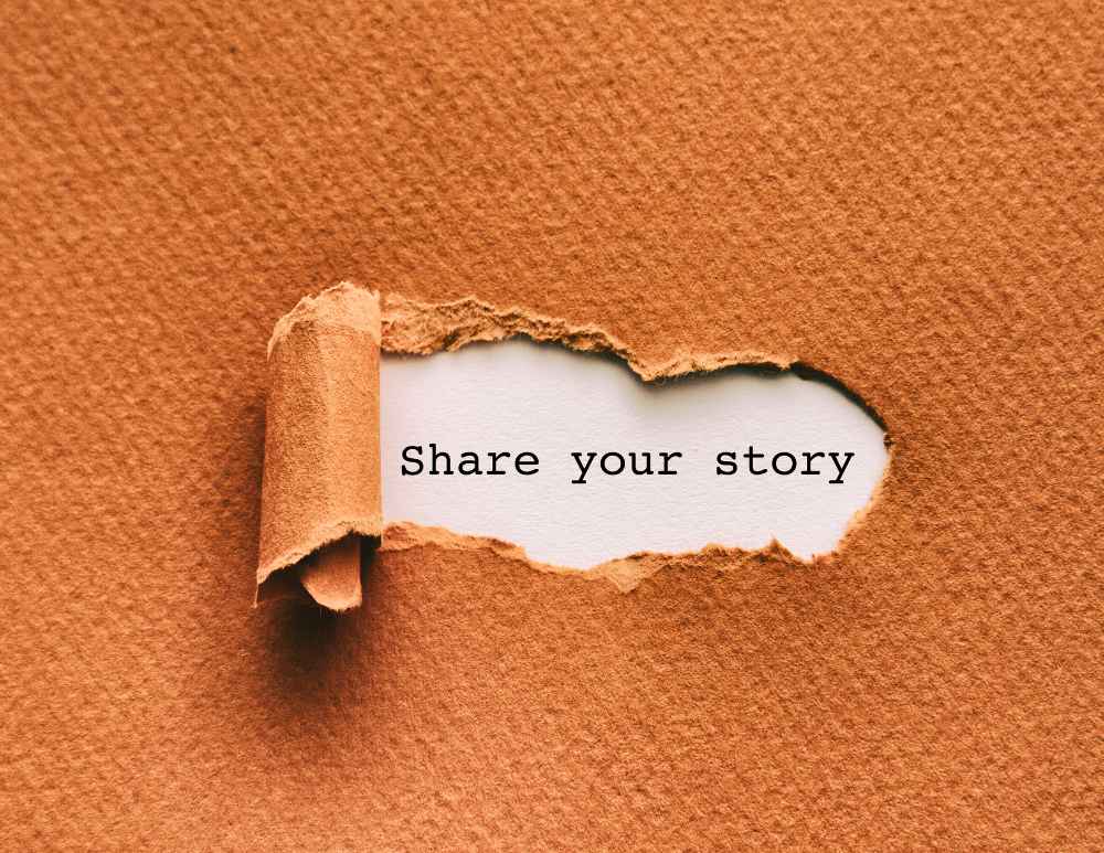 A rip in paper reveals the phrase "Share Your Story".