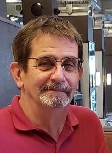 image of gentleman with brown hair, glasses, and wearing a red golf shirt