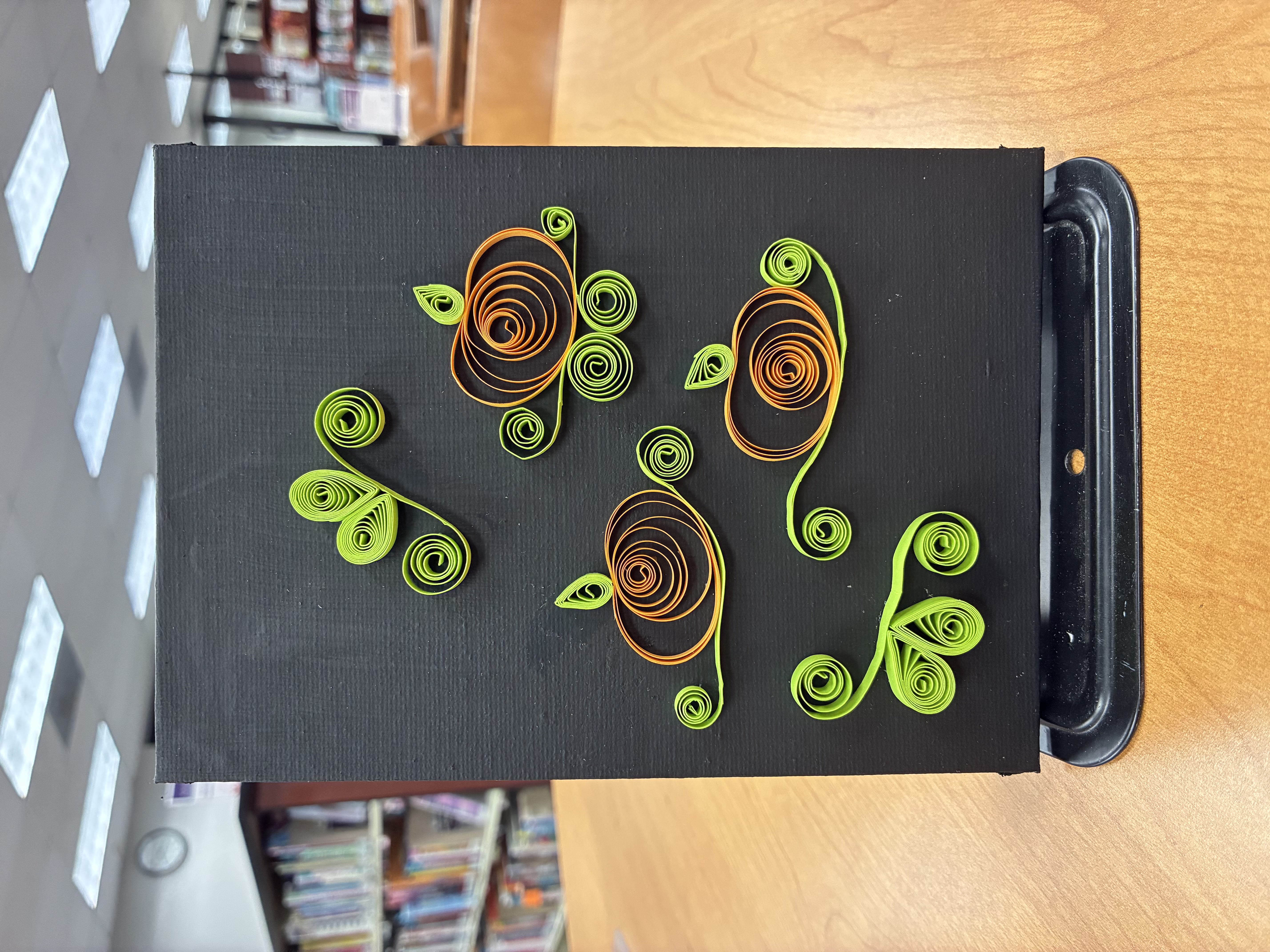 Image of quilling art example; black 5x7 canvas with three pumpkins and leaves/vines