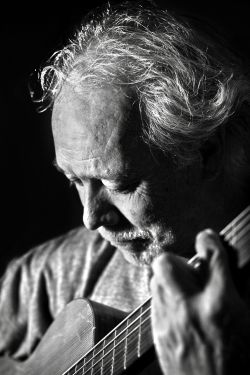 black and white image of man playing guitar