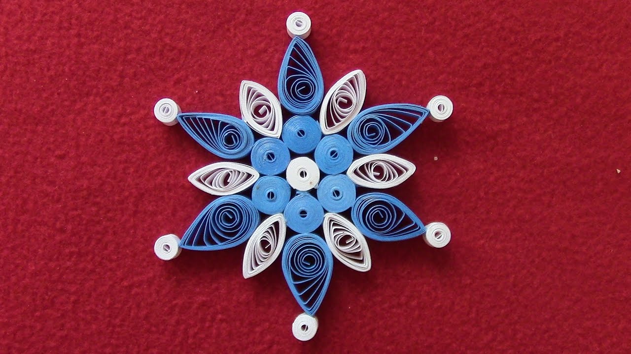 Quilled snowflake craft made with rolled pieces of paper.