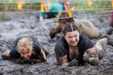 athletes crawling through mud