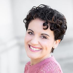 Image of a smiling woman with short dark hair wearing a pink shirt. 