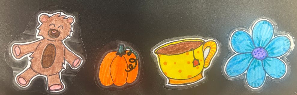 DIY Crafts: Sticker Example including a bear, pumpkin, tea cup, and flower on a black background