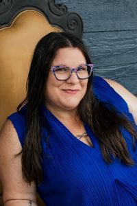 woman with glasses sitting in a high back chair