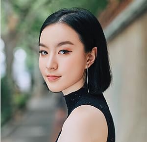 A headshot of a woman with black hair and a black sleeveless shirt. 