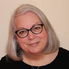 headshot of woman with white hair and glasses