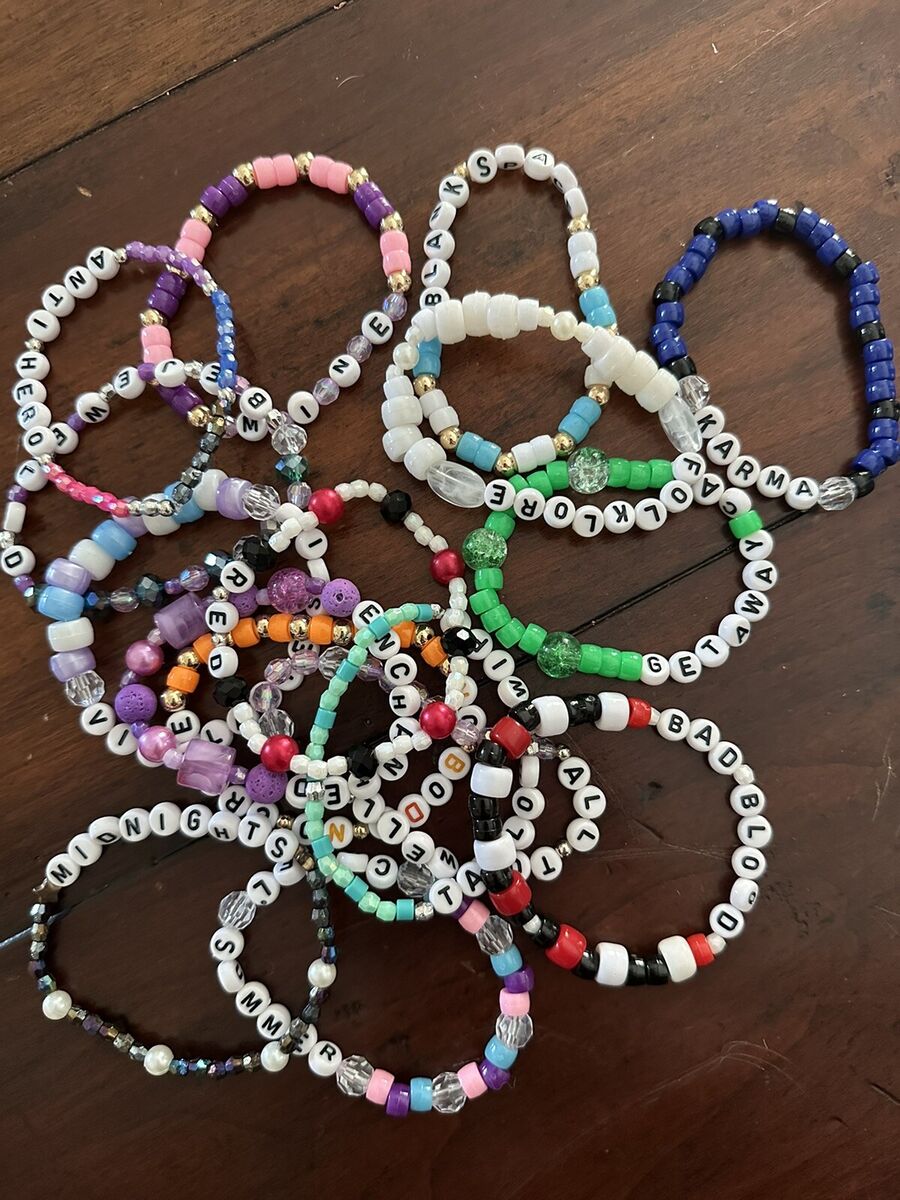 Examples of Eras Tour friendship bracelets spread out on a wooden table