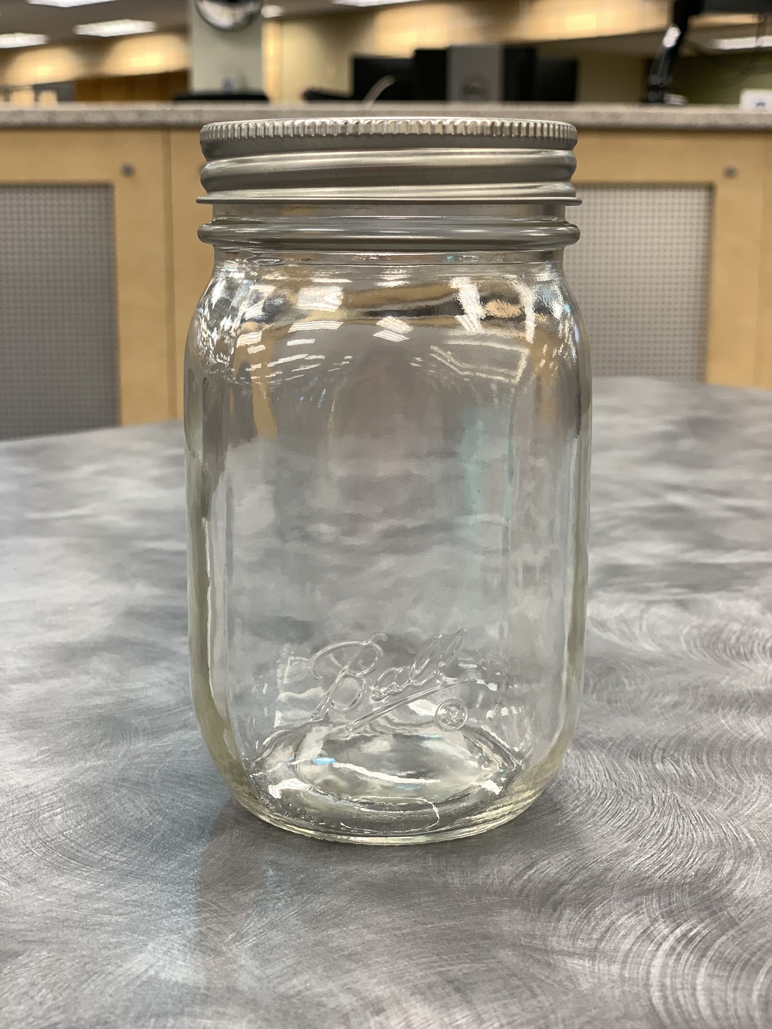 Clear empty mason jar sitting on gray table