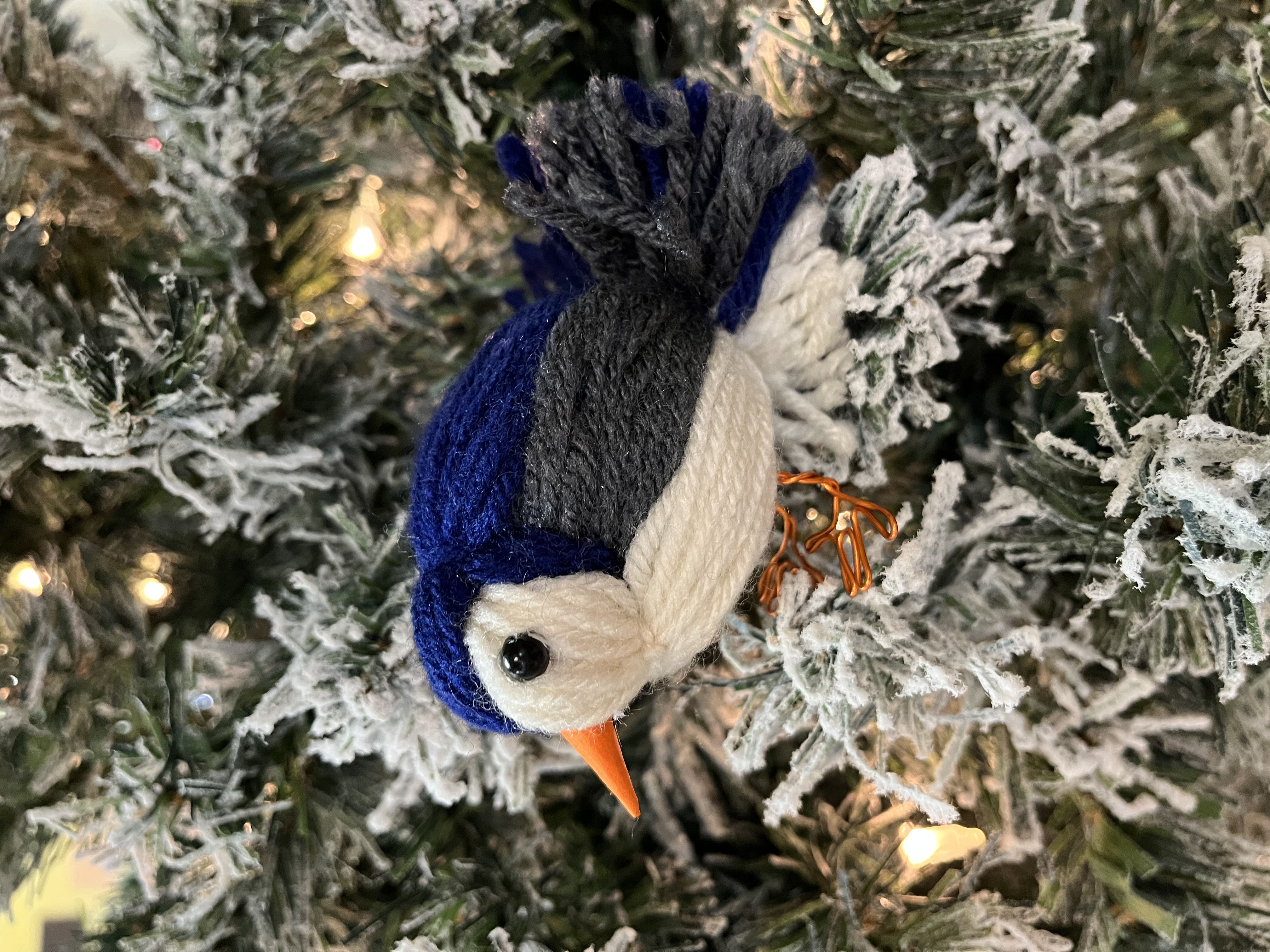 Yarn bird decoration sitting in a tree