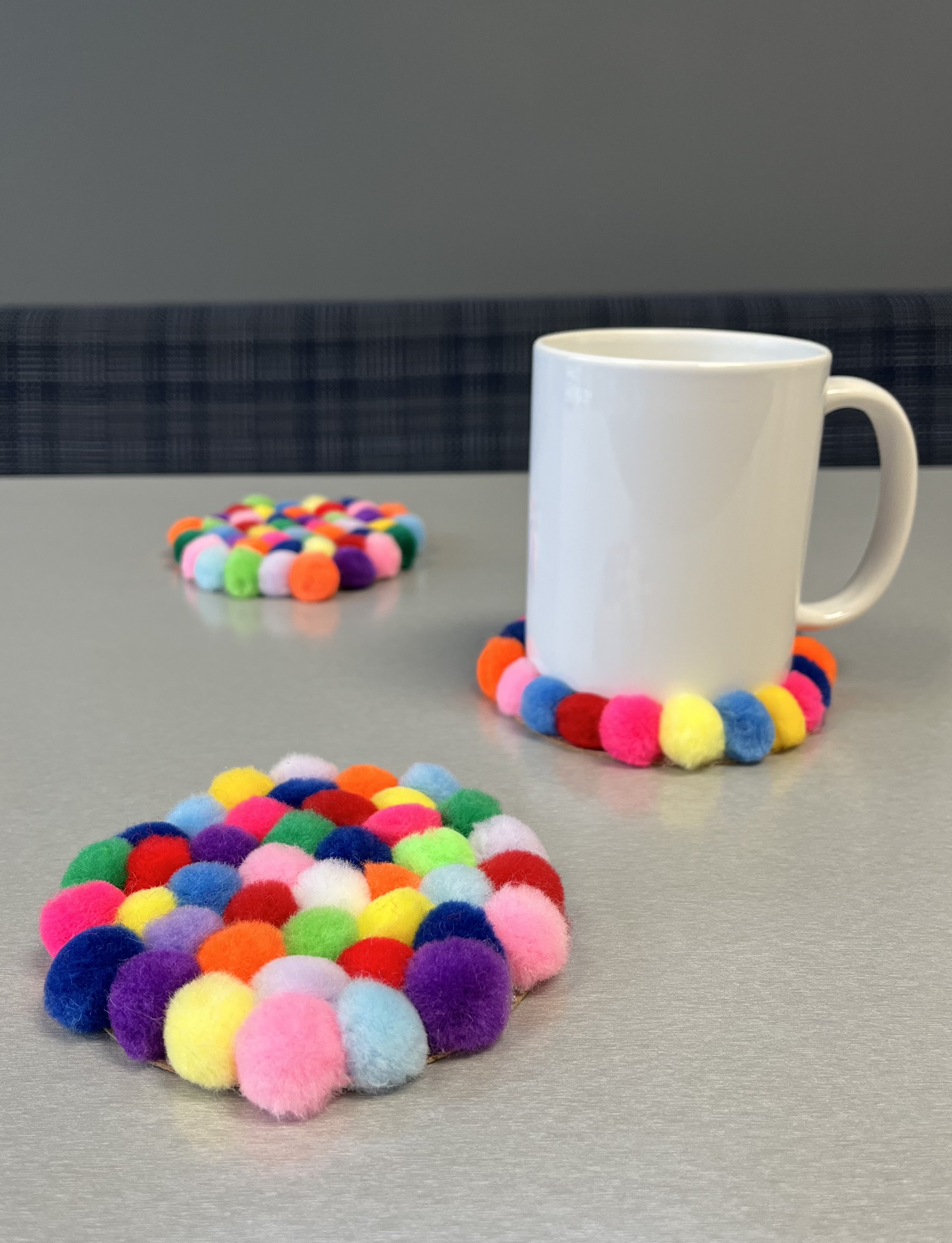 Pom pom drink coasters with a coffee mug