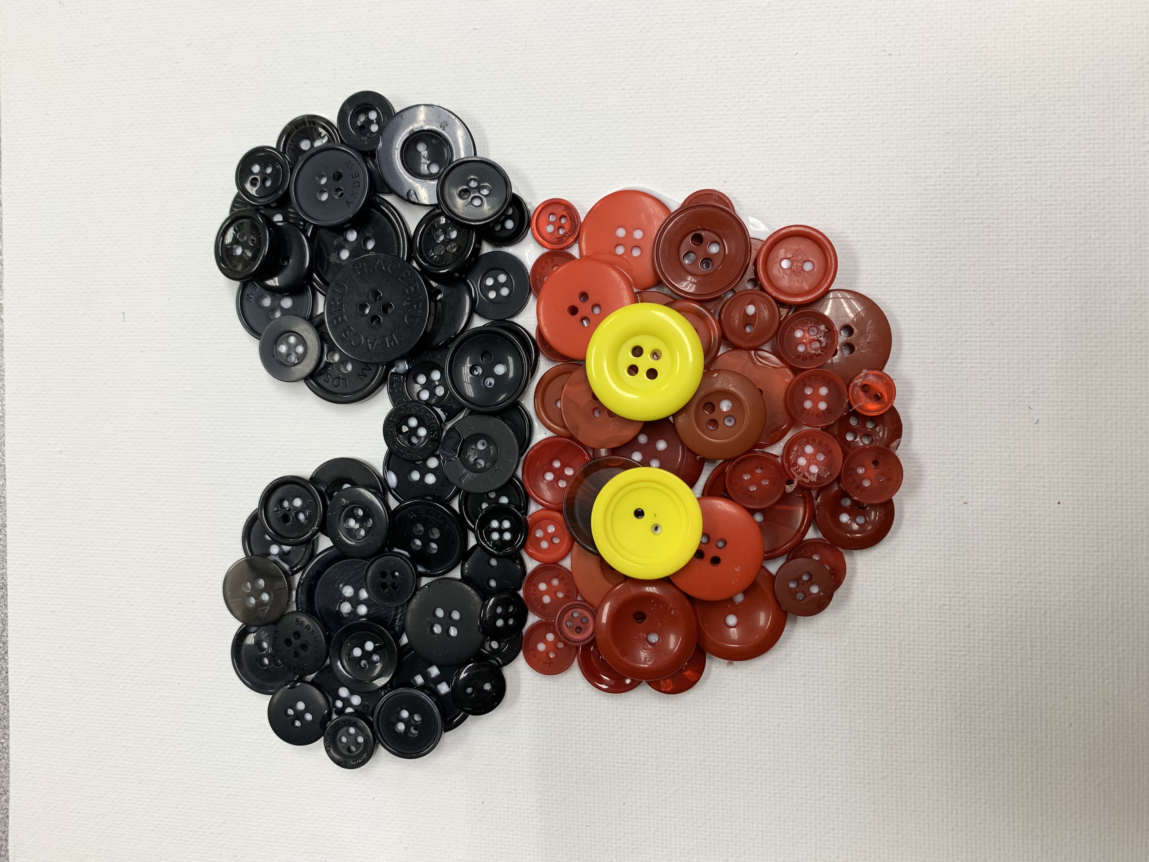 Mickey Mouse icon made out of black buttons for ears and red buttons for body