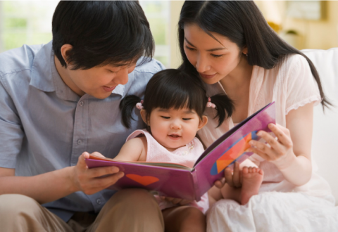 Father and mother reading with toddler