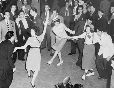 A black and white photo of men and women dancing. 