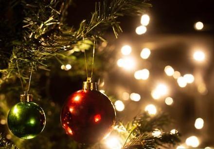 Two ornaments on a Christmas tree. Surrounded by white lights.