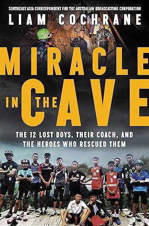 group of boys in front of a cave