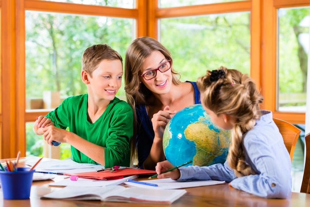 A boy and girl learning at home with their mother. 