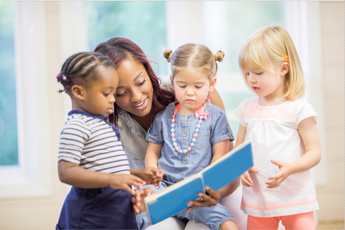 Woman reading to group of toddlers