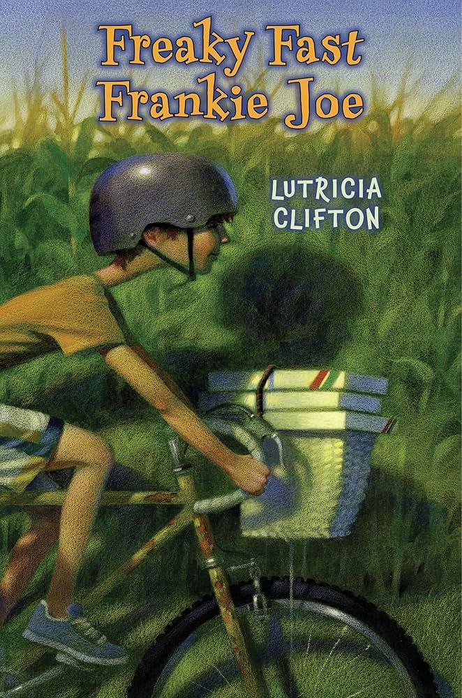 A boy rides his bike next to a corn field.